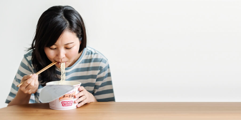 Woman eating instant ramen noodles
